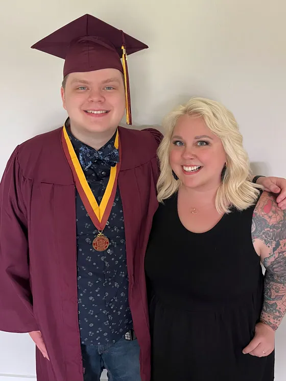 Mother and teenage son pose for an image with arms around each other