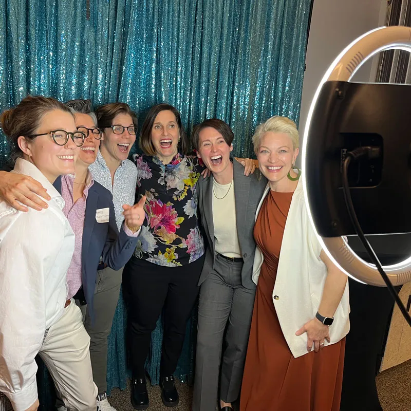 A group of women posing in front of the camera with arms around each other